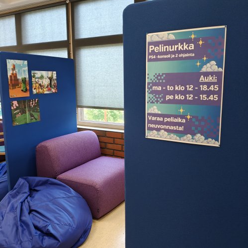 Kuva pelinurkan istuimista. Violetti nojatuoli ja sininen säkkituoli sermien välissä, ikkunan vieressä.