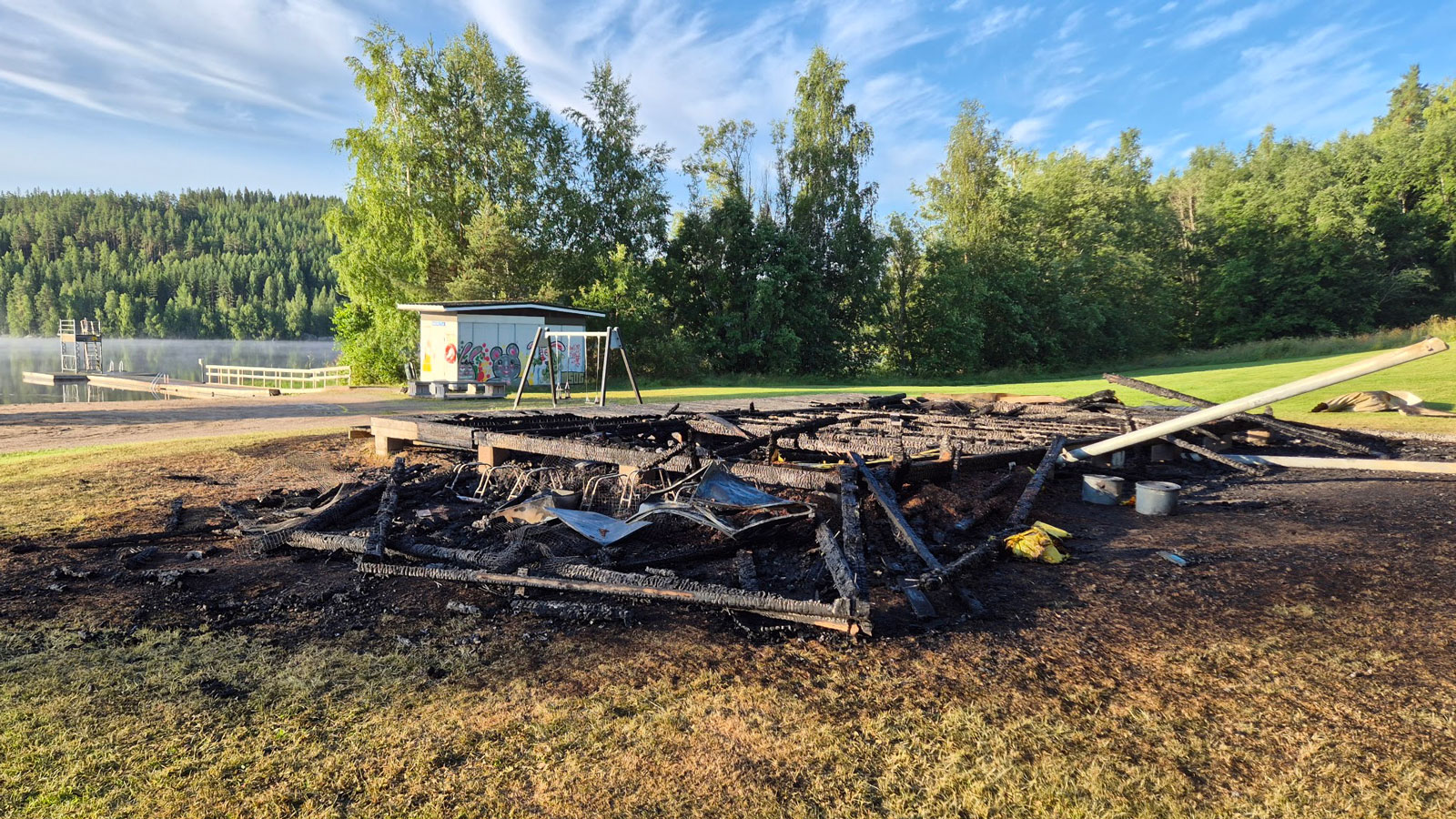 Suojärven uimakopin hiiltyneet jäännökset kesäisessä aamuauringossa